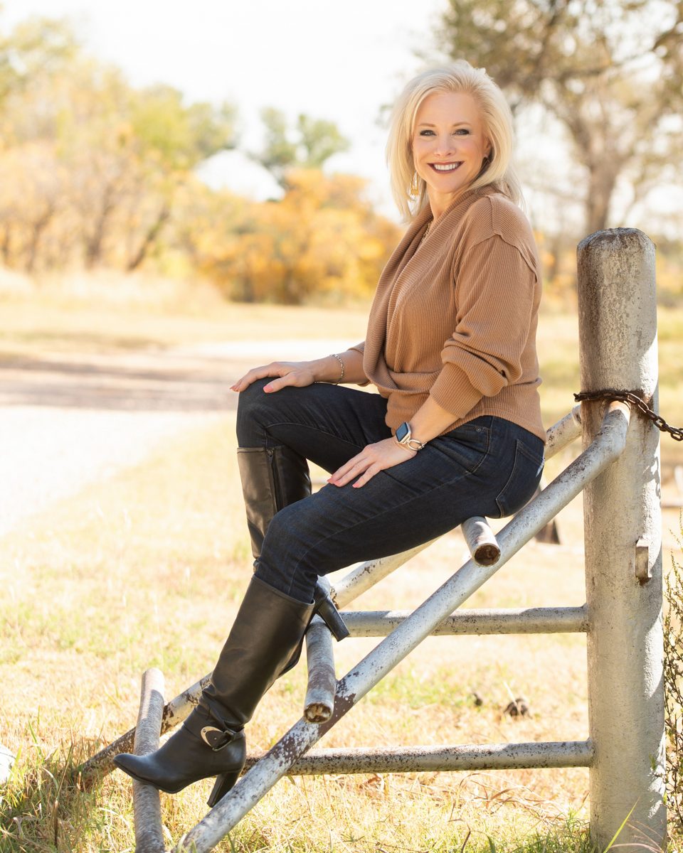 Linda Joy sitting on a ranch fence in the Texas Panhandle