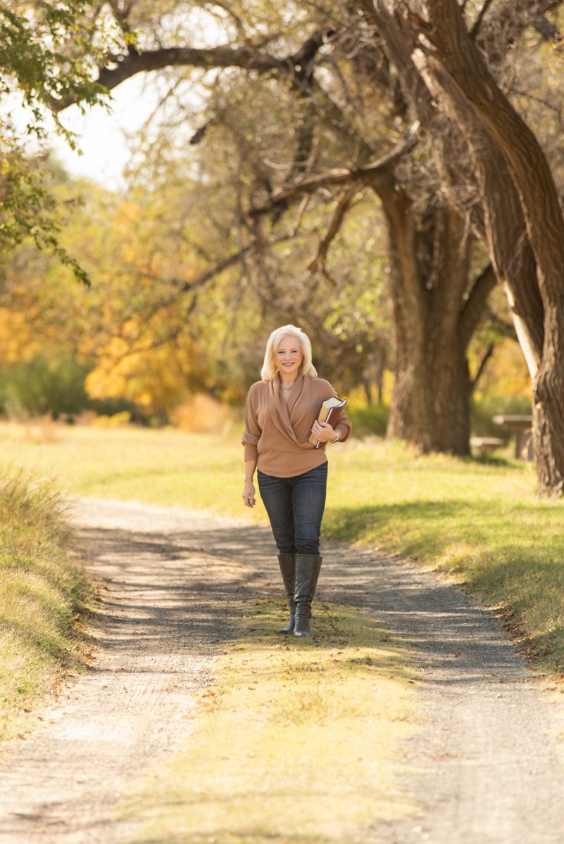 Linda Joy walking down a tree-lined country road